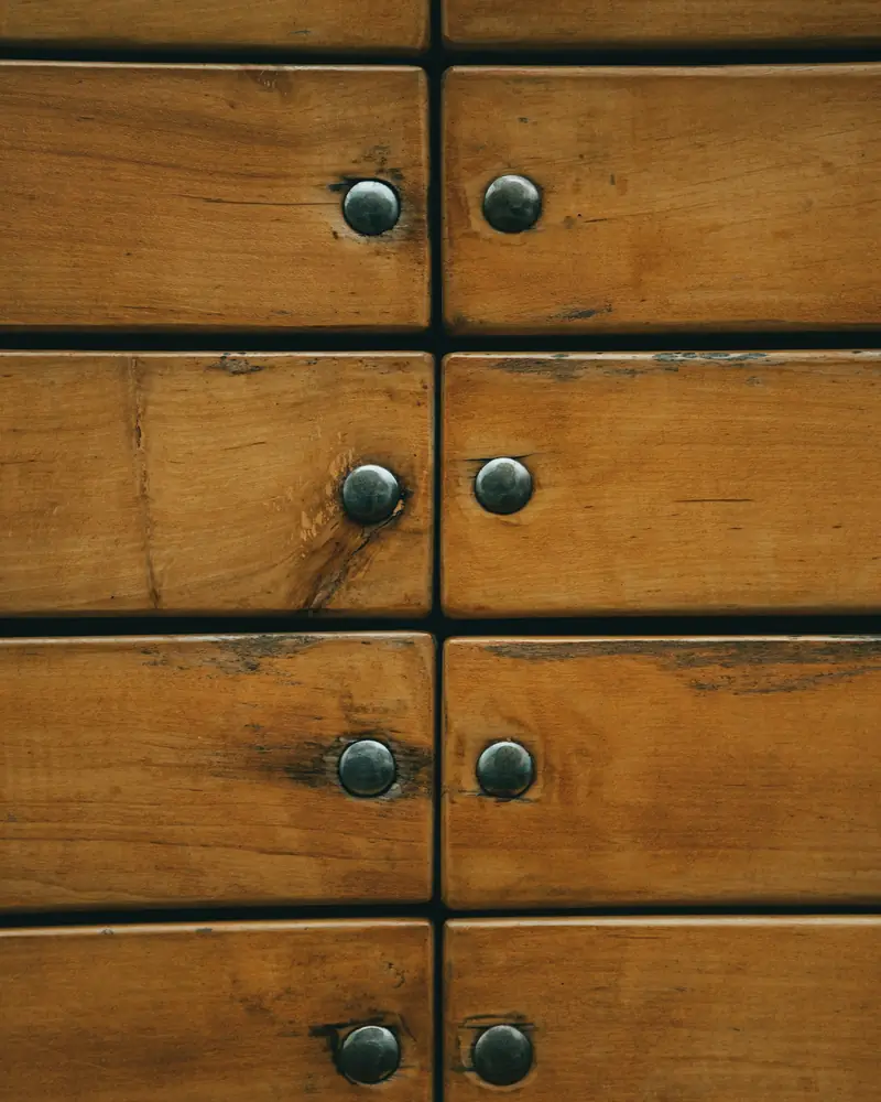 Façade de petits tiroirs en bois à boutons métalliques